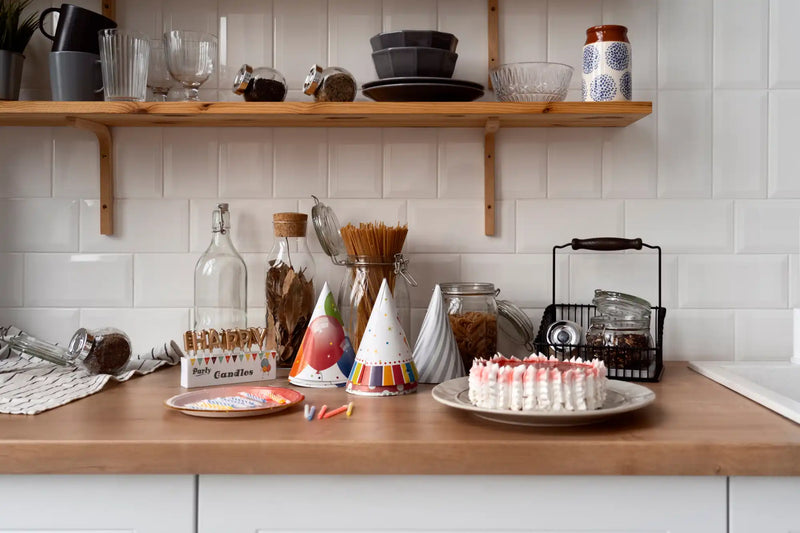 A white, round cake with pink frosting and decorative piping.